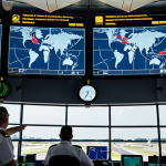 **Prompt:** Busy air traffic control tower at Schiphol Airport, multiple radar screens displaying flight paths, controllers communicating with pilots, realistic, daytime.